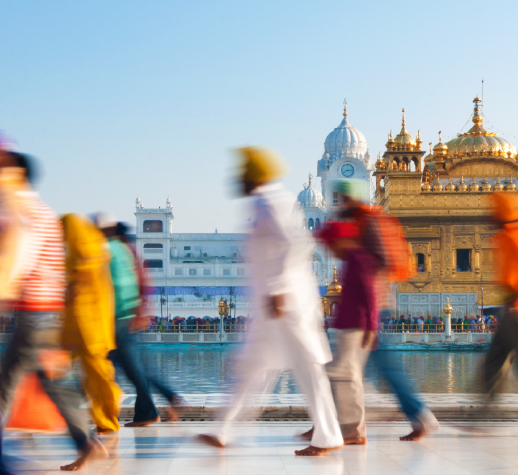 Group of Sikh pilgrims walking by the holy pool, Golden Temple, Amritsar, India